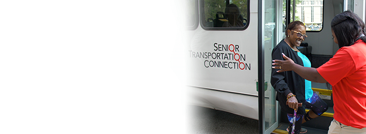 Person assisting another person onto a Senior Transportation Connection Bus